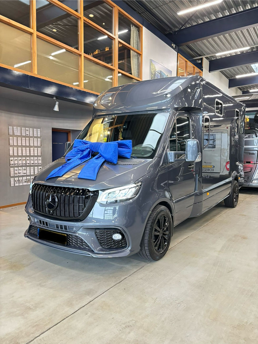 Grey Mercedes-Benz commercial van with a blue gift bow at Zuuring Car Care in Heteren, ready for a premium client handover after professional showroom-grade detailing and protection services