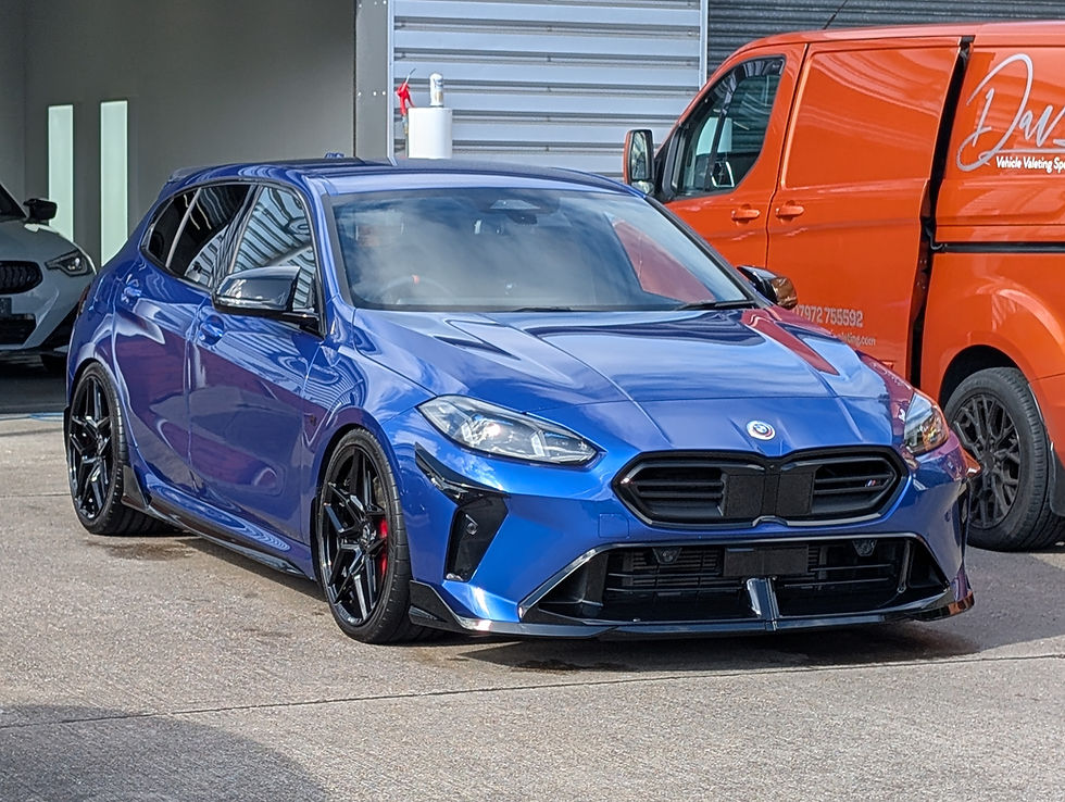 Blue BMW car parked, Dave Detailing logo on orange van in background.