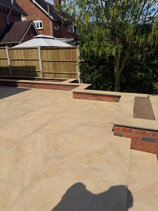 A well-designed backyard patio with a wooden fence and a gazebo Kt-Landscaping
