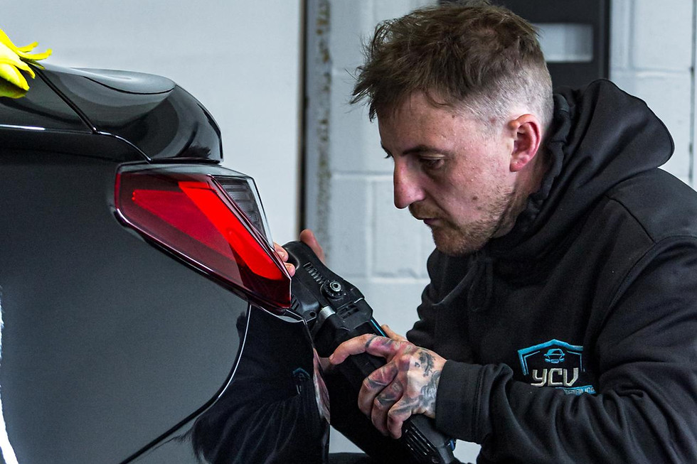 Technician detailing a black car