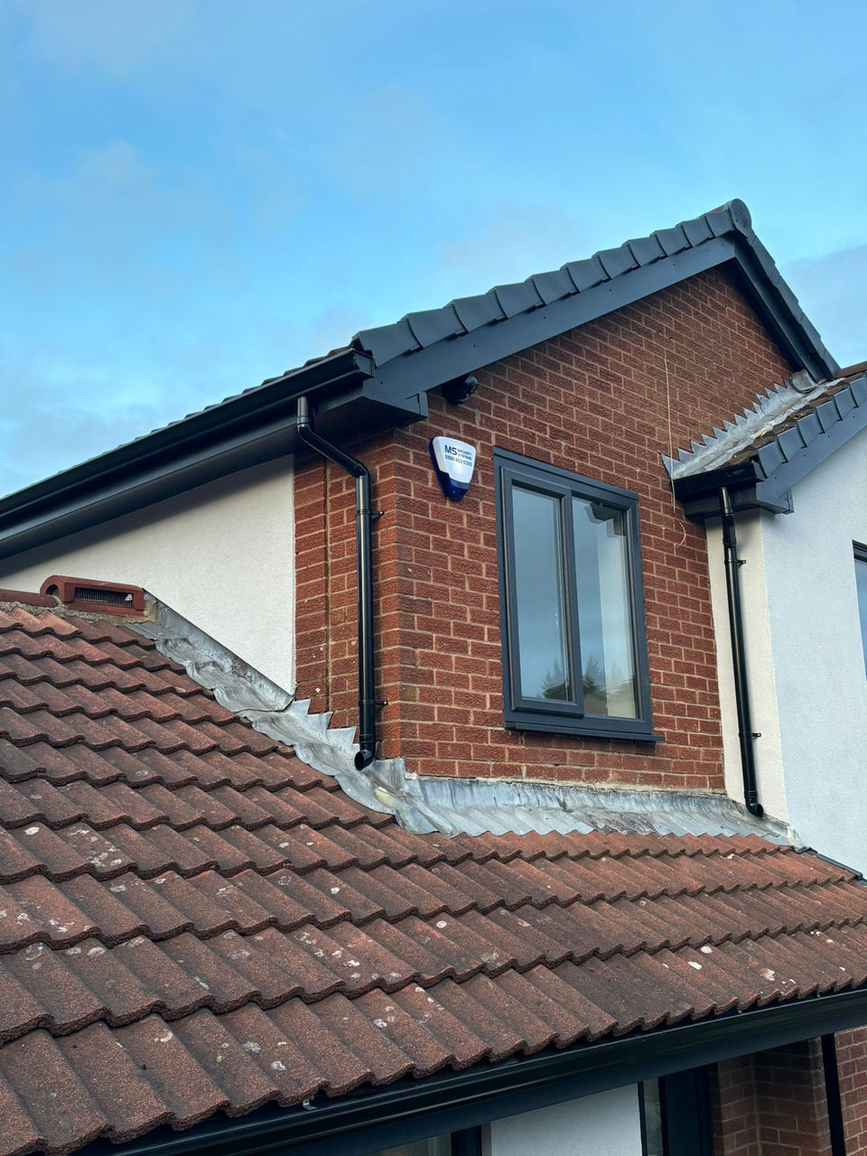 Black seamless gutters on a house roof