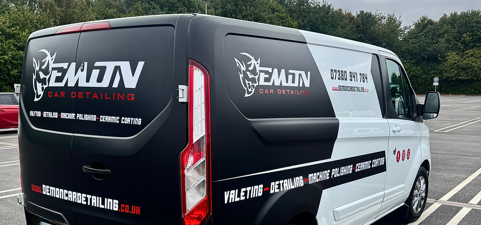 Black and white van with 'DEMON AUTO CARE REPAIR' branding