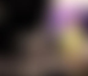 Sian Williams in a yellow dress stands in a makeshift studio with cameras, lights, and a purple screen. A camera viewfinder shows her image.