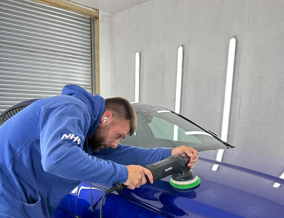 Technician polishing blue car's hood, Bristolbubbles