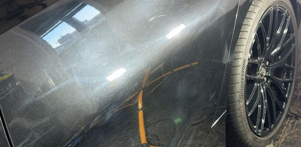 Scratched black car door needs repair