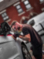 Man polishing silver car with buffer