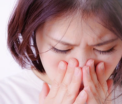 鼻を押さえる女性