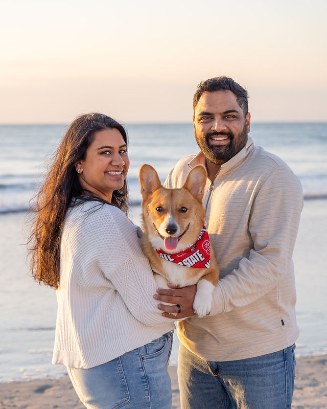 couple at beach with one corgi