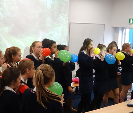 A group of school girls (teenagers) blowing up balloons in Rethinking Revision science workshop