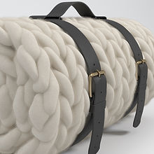 Imagem de Bloco 3D com manta de tricô enrolada presa com tiras de couro