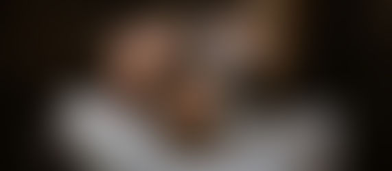 Client relaxing at a shampoo bowl while a stylist gently rinses her hair, highlighting a calm, luxury wash experience.