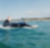 woman paddling on a surfboard in the ocean, waves, blue sky and a sunny day. alicehelenferguson