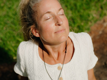 Frau mit geschlossenen Augen in der Sonne sitzend