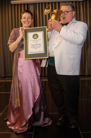 Committee member Loz McConnachie presents Craig Glenday his certificate and hand-made one-of-a-kind trophy for winning the Bell-End of the Year award. This light-hearted prize recognises the player who brings the most fun to rehearsals and concerts.