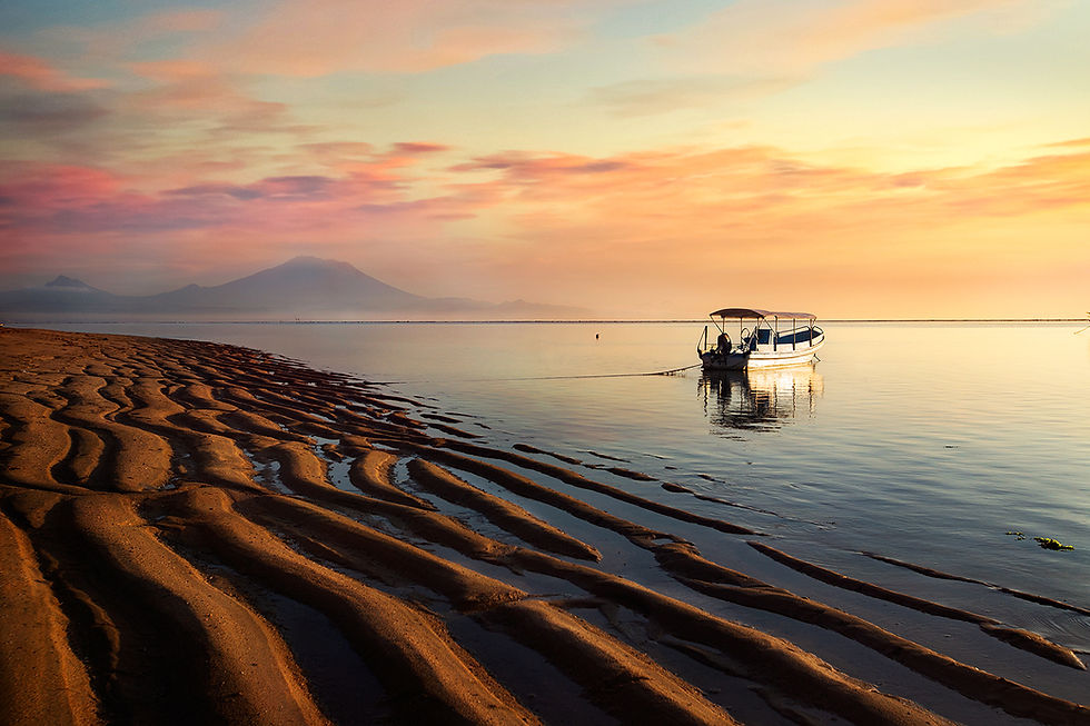 Mount Agung, golden sand, and a boat sits on calm waters, peaceful morning at Sanur Beach Bali