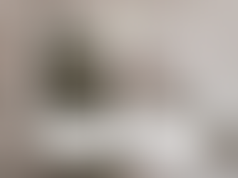 An image of a hand holding up a gold christmas ornament. 