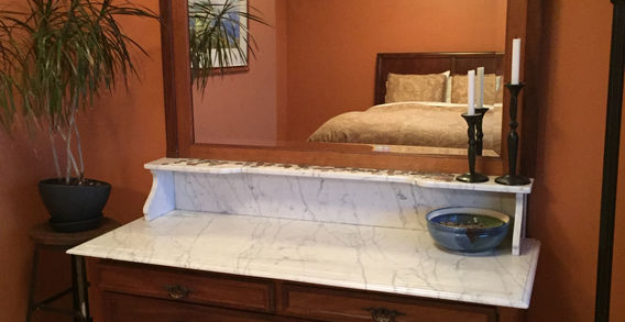 A wooden dresser or sideboard with 5 drawers and large mirror.