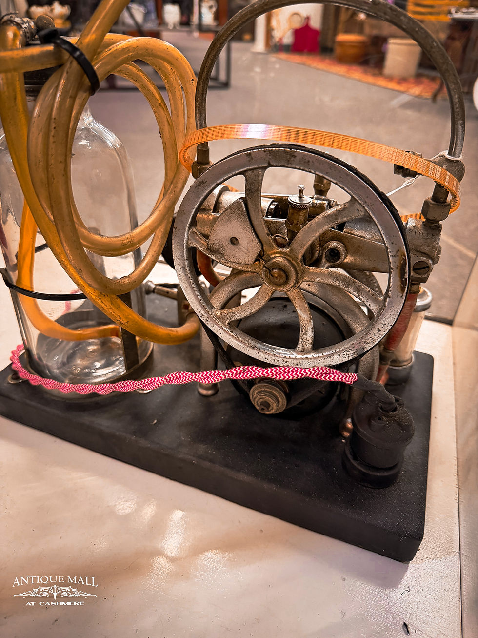 A back view of an antique embalming machine showing gears and tubing.