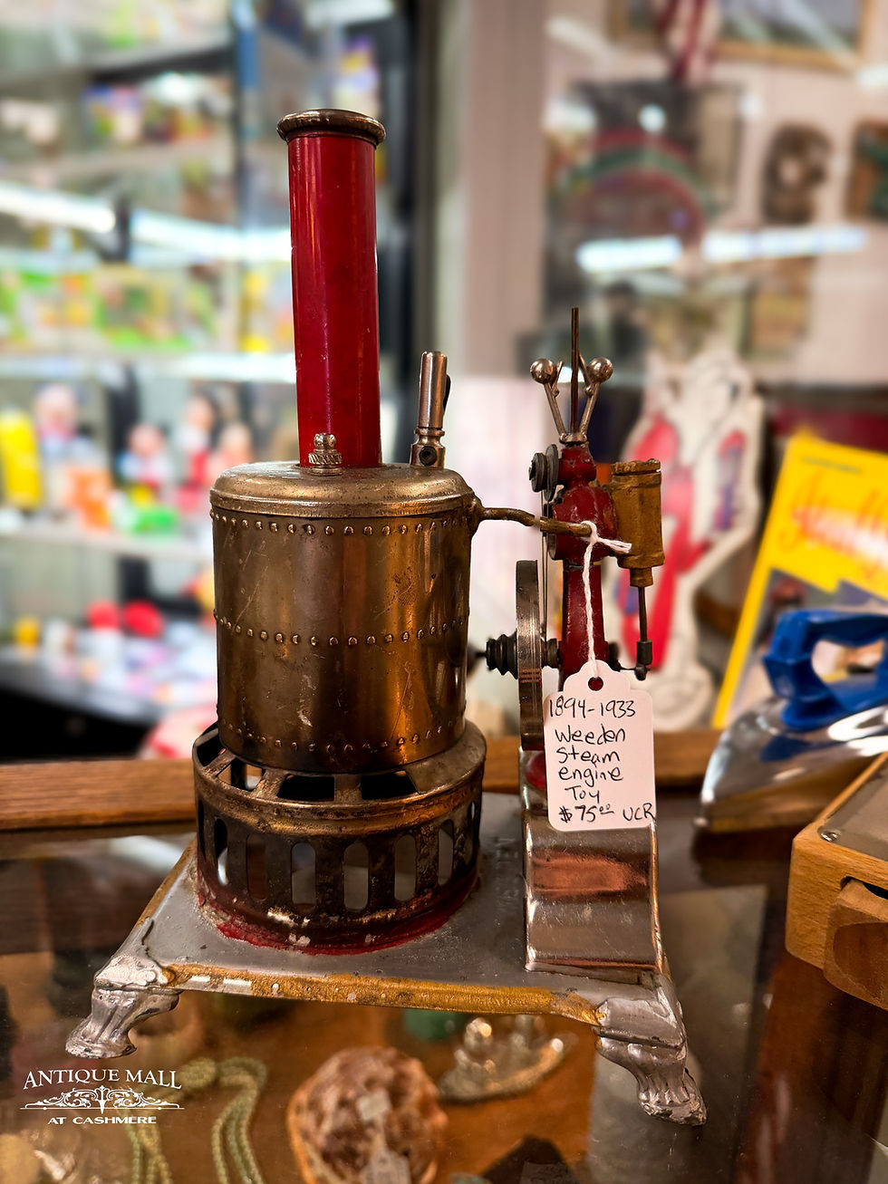A metal steam engine with a red steam stack.