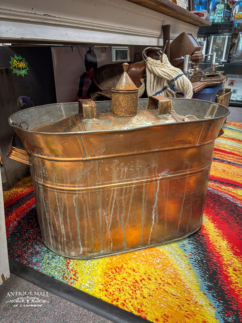 A large copper tub with lid, stem pipe, and handles sits on a colorful carpet in a booth.