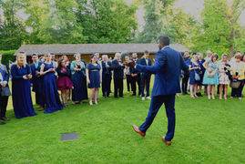 Un homme parle à un groupe de personnes lors d'un événement extérieur.