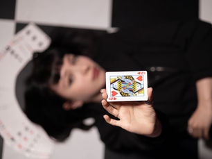 Dame de cœur présentée face à l'objectif sur un damier noir et blanc, visuel d'ambiance pour un spectacle d'hypnose et de mentalisme.