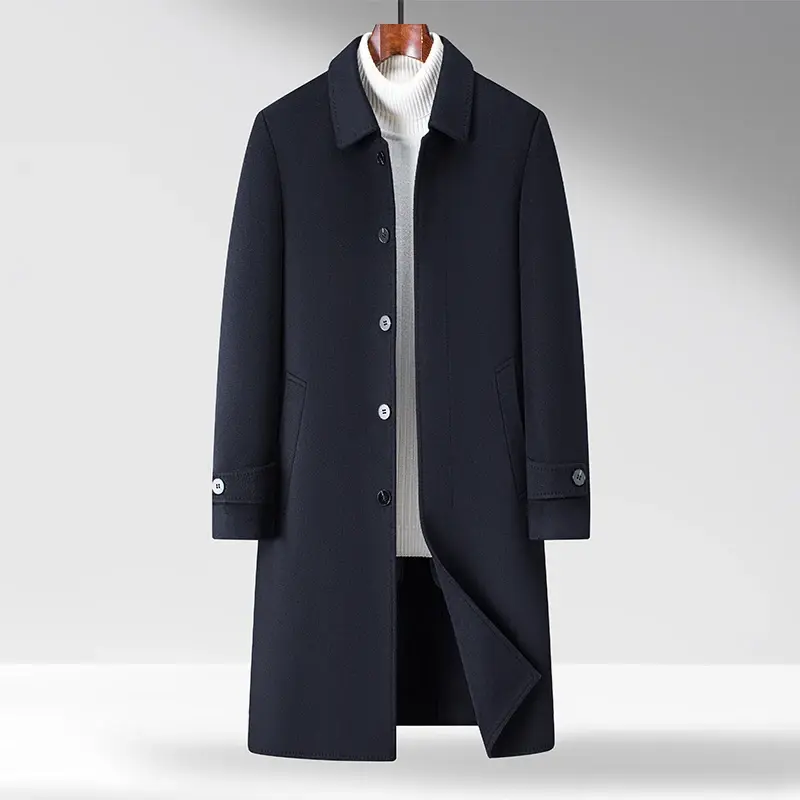 Dark navy overcoat with buttons, folded cuffs, and slant pockets, layered over a white ribbed turtleneck sweater.