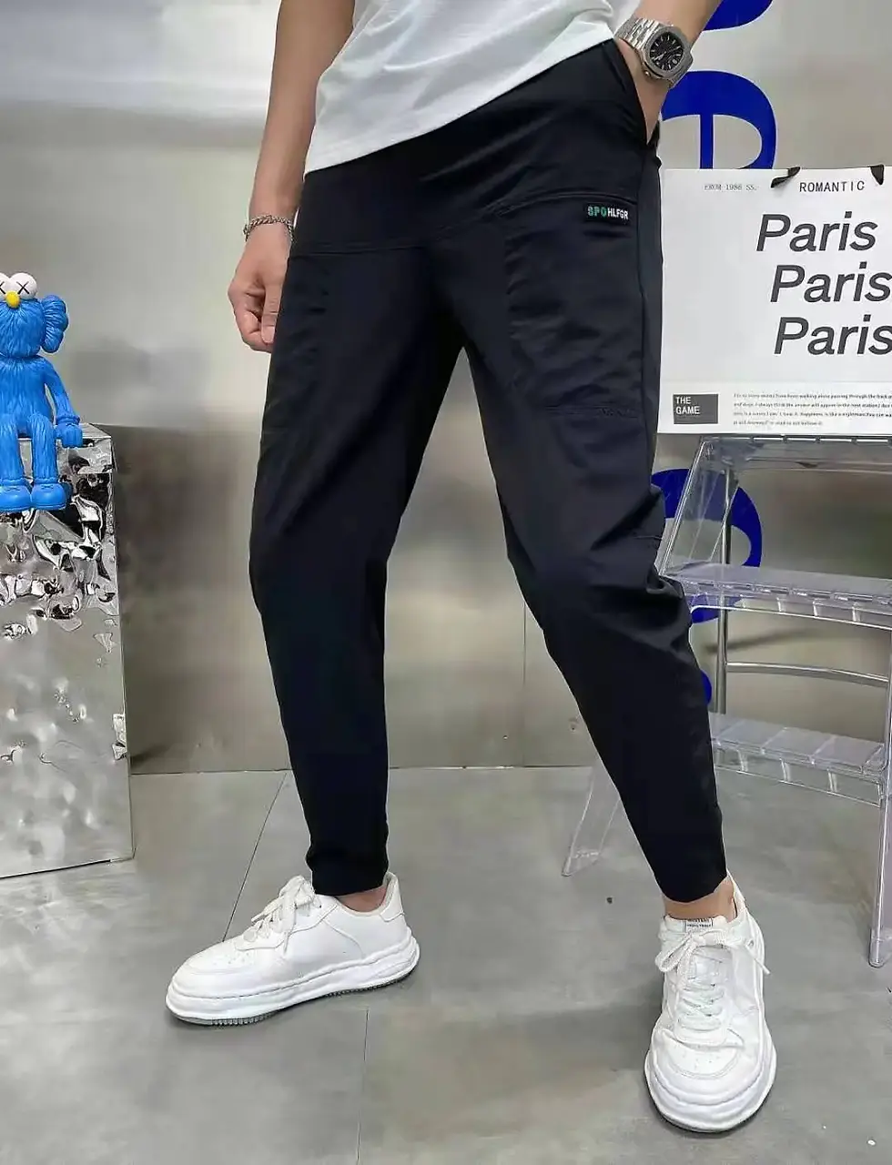 Thumbnail: Gray cargo pants displayed from front and back on a model wearing white sneakers and a shirt, with a striped background.