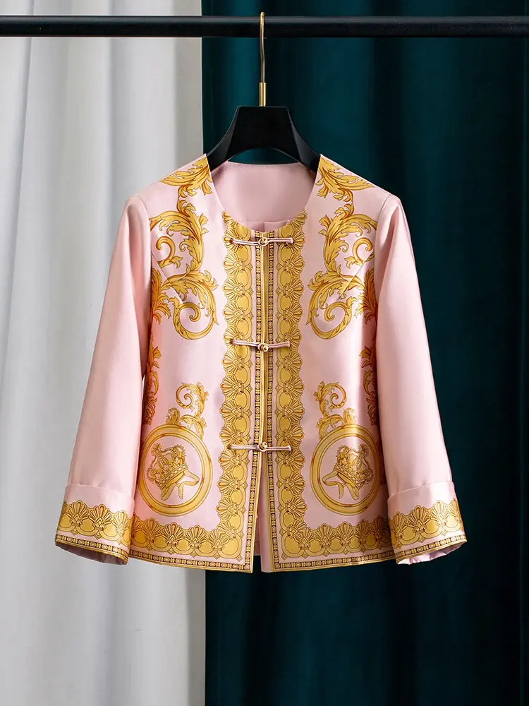 Pink jacket with intricate gold baroque patterns and decorative buttons on a hanger.