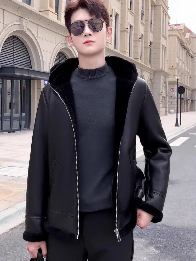 Miniatyrbilde: Person in black leather jacket with fur lining, dark pants, and sunglasses stands on a city street with arched windows.