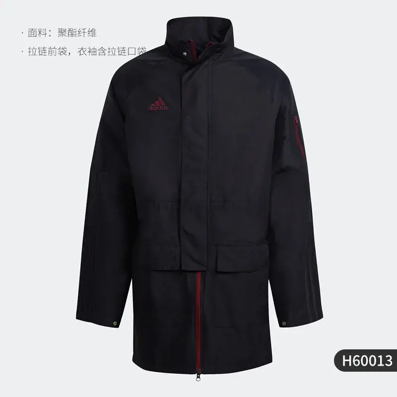 Thumbnail: Man in a long black jacket with red details, standing against a gray background.