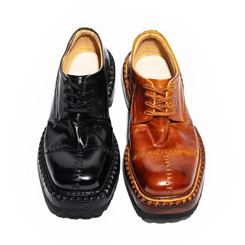 Black and brown leather shoes with thick, stitched soles and a glossy finish on a white background.