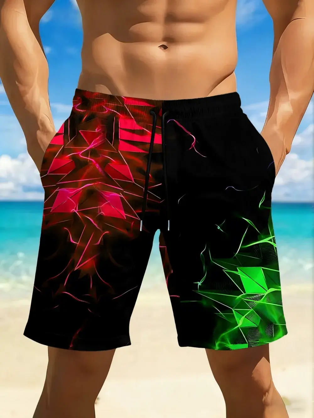 Man wearing black shorts with red and green geometric patterns on a beach, clear blue sky and ocean in the background.
