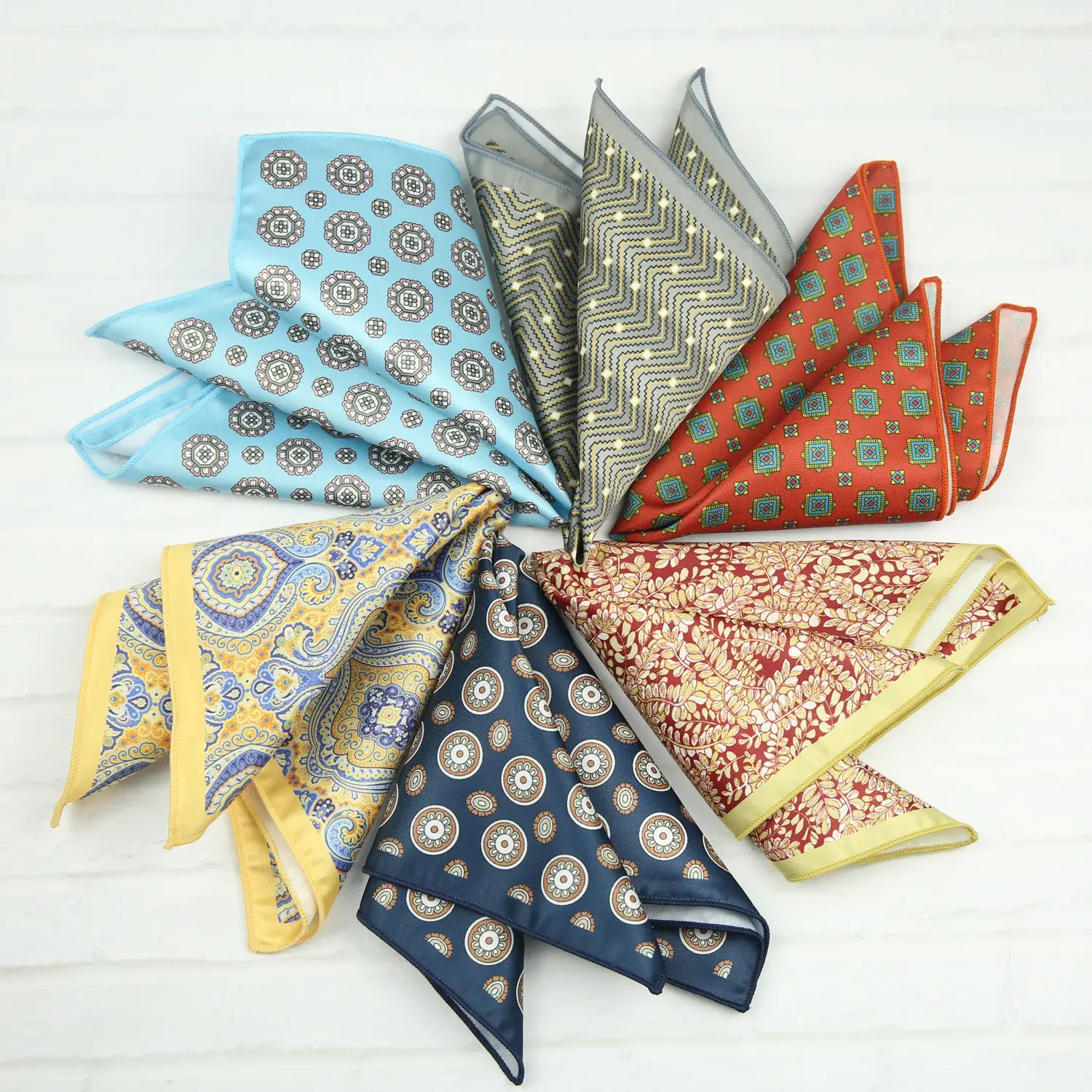 Colorful pocket squares arranged in a circle, featuring various intricate patterns and colors like blue, red, and yellow.