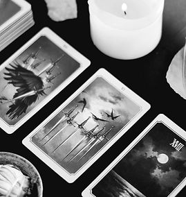 a photo of various tarot cards out on a table with a lit candle