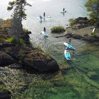 A group paddling between the Gordon Bay Islands - Pristine Paddleboard Adventures