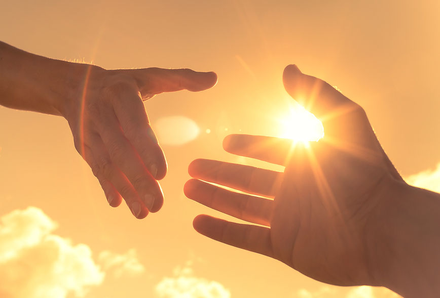 Hands reaching out to each other with sun in the background