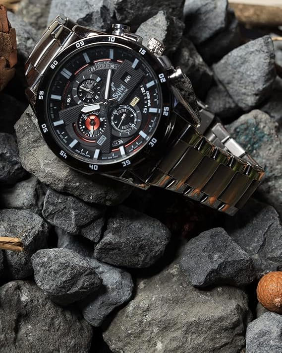 Thumbnail: Silver wristwatch on rocks. Black dial with multiple sub dials and details.