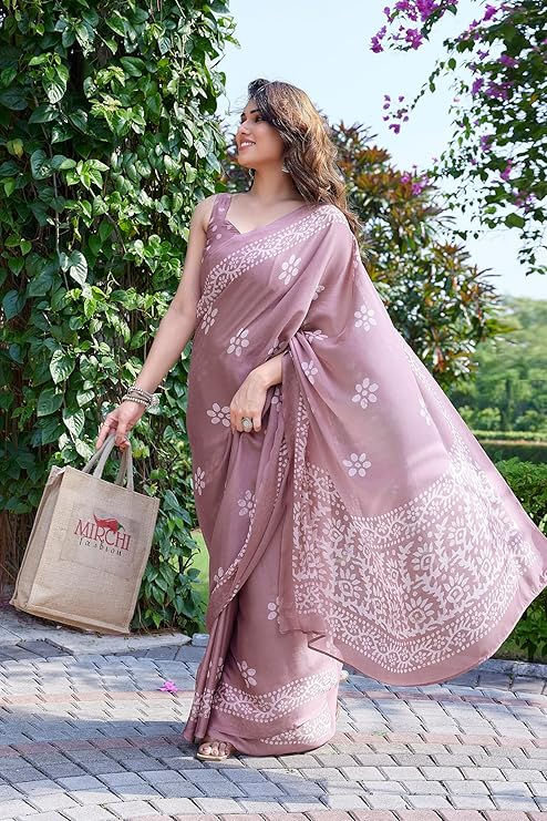 Thumbnail: Woman wearing a mauve saree holding shopping bag, walking outdoors. Shopizo