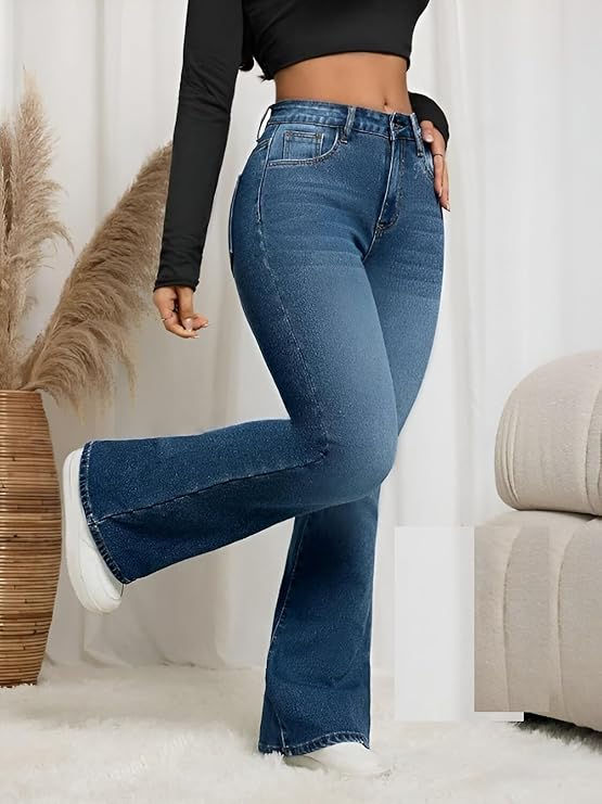 Thumbnail: Woman wearing black top and blue jeans, standing in front of plant
