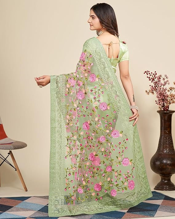 Thumbnail: Woman wearing green saree with floral embroidery posing near a vase Shopizo