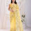 Thumbnail: Woman wearing yellow floral saree, standing gracefully, Shopizo in background.