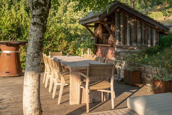 Table, chaises et bar dans le jardin d'une location de chalet avec jacuzzi