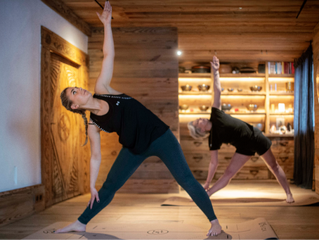 Deux femmes font des étirements de yoga dans un chalet de luxe proche de Genève