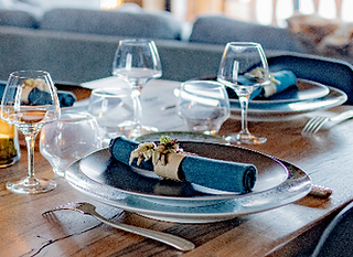 Une table élégante avec des photophores et de la porcelmaine Nymphea JL Coquet dans un chalet près de Megève