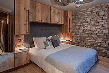 Lit suite Aiguilles Rouges avec mur en pierre dans un chalet en Savoie