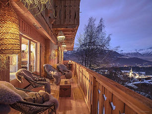 Balcon de chalet de montagne en bois au crépuscule vue sur la vallée
