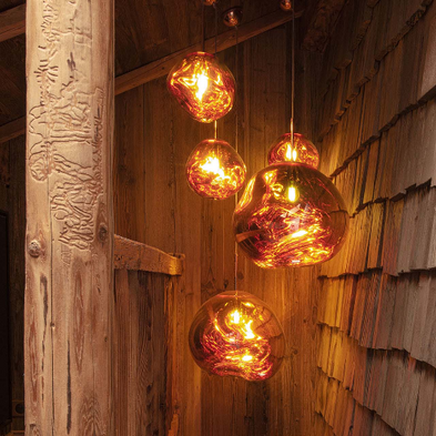 Une cascade de luminaires Mel de Tom Dixon dans un chalet.