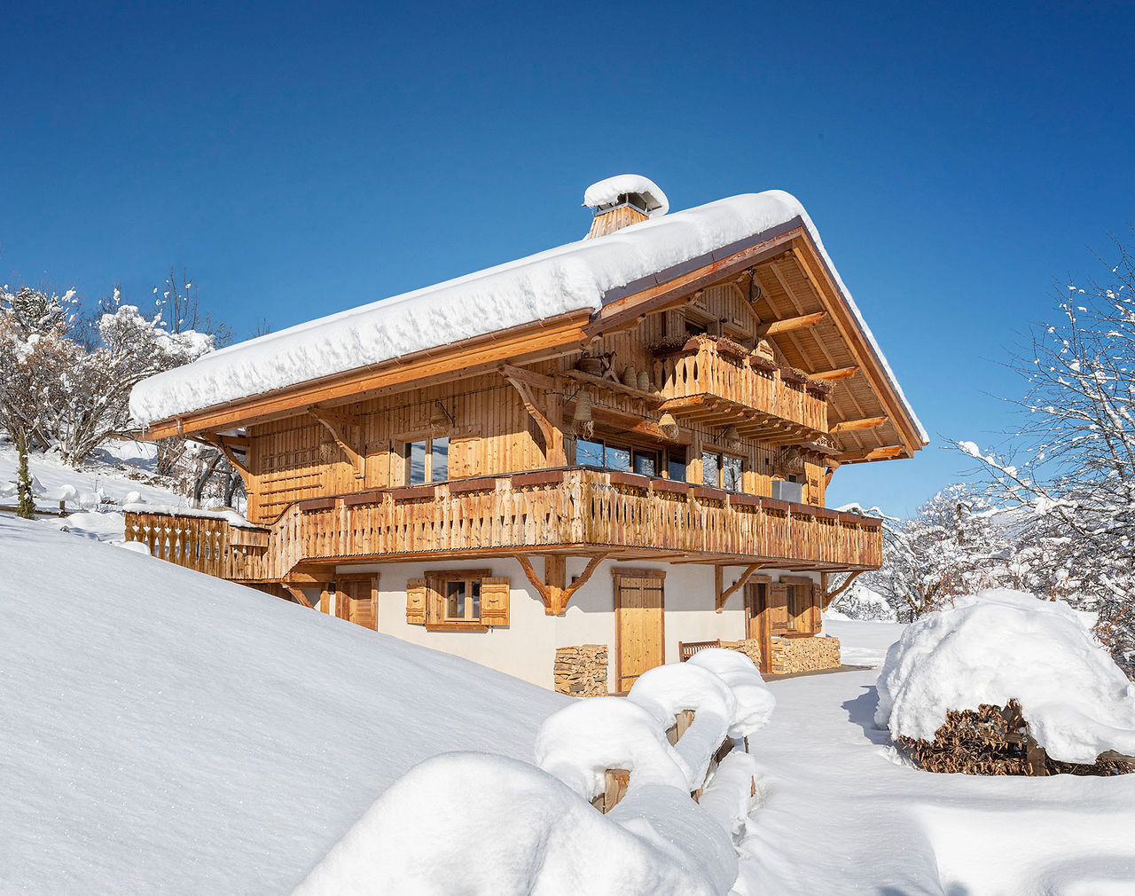 chalet en bois couvert de neige sous un ciel bleu