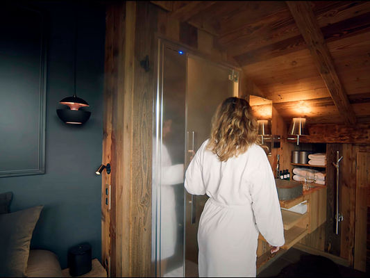 Femme entrant dans un hammam dans un chalet avec spa